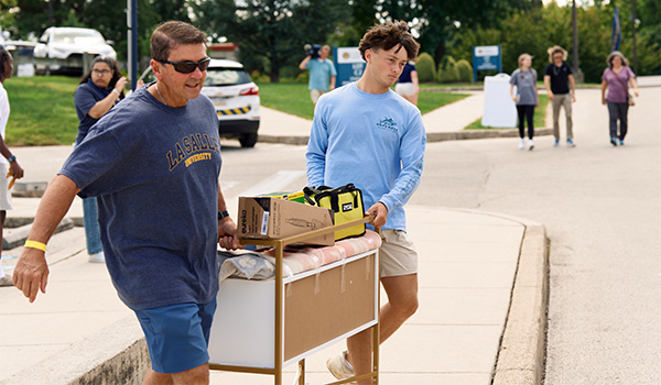 Image of a father and son moving into the dorms.